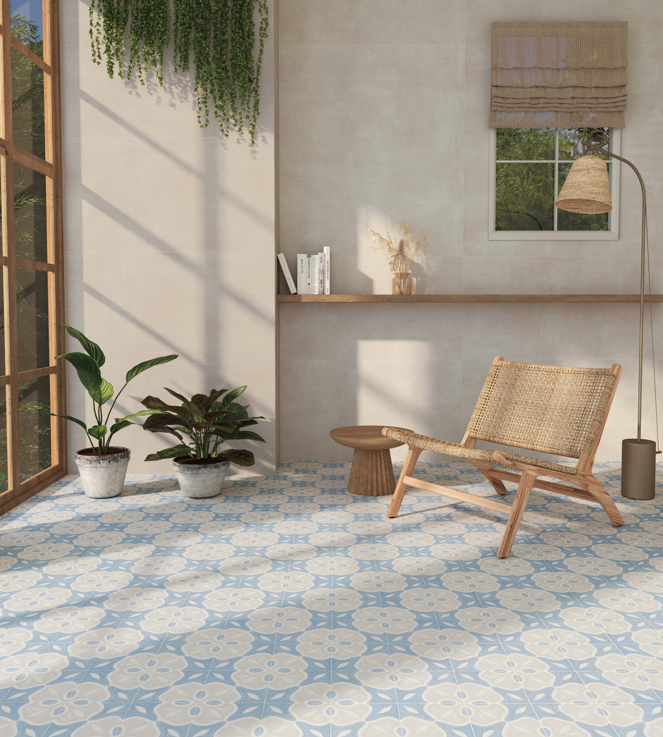 Bright and airy indoor space with patterned blue and white ceramic tiles, a wooden lounge chair, potted plants, and natural light streaming through large windows.